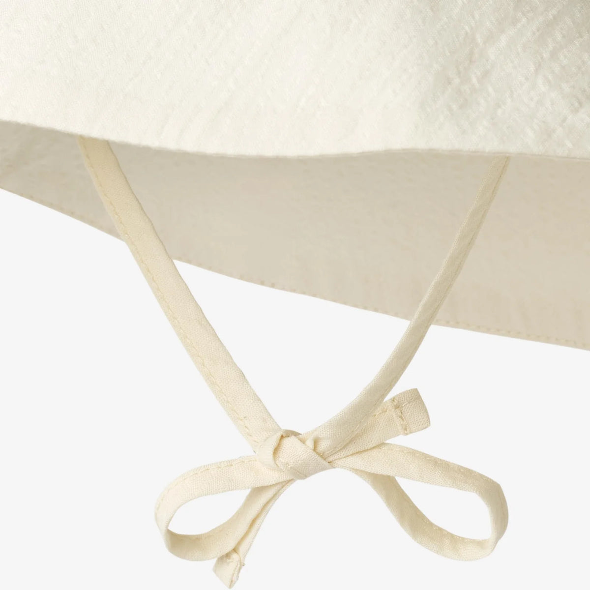 Close-up of a beige sun hat with a ribbon on a white background