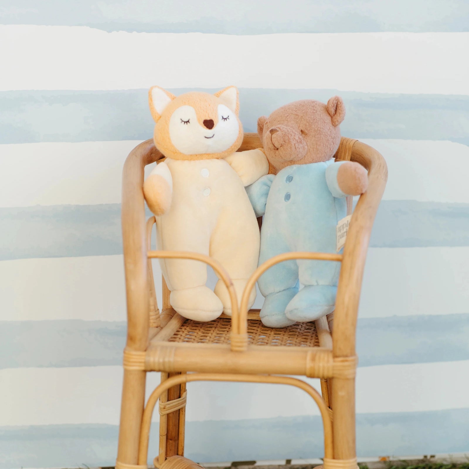 Stuffed teddy bear in a blue outfit on a white background