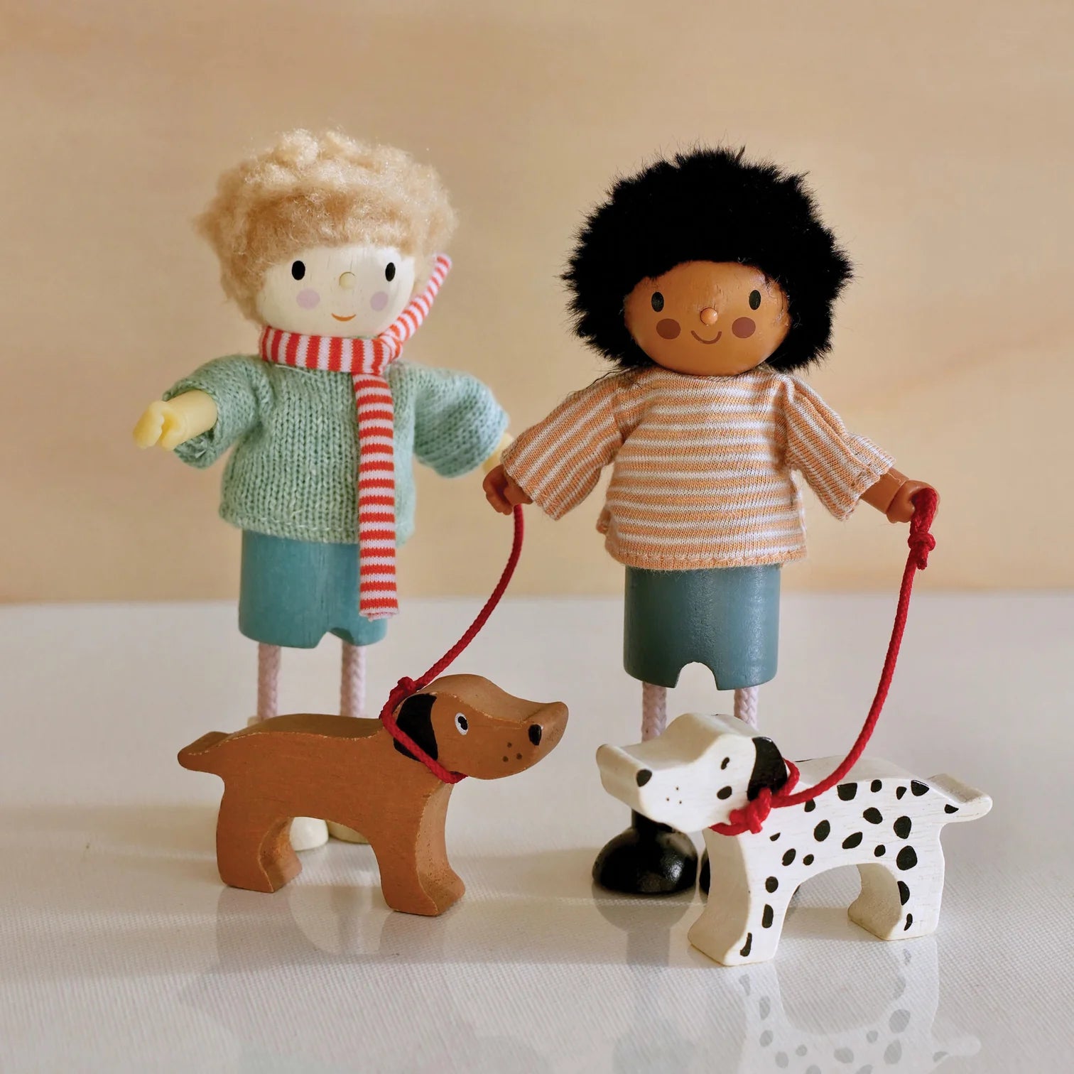 Wooden toy figure with a striped scarf and a wooden dog on a white background