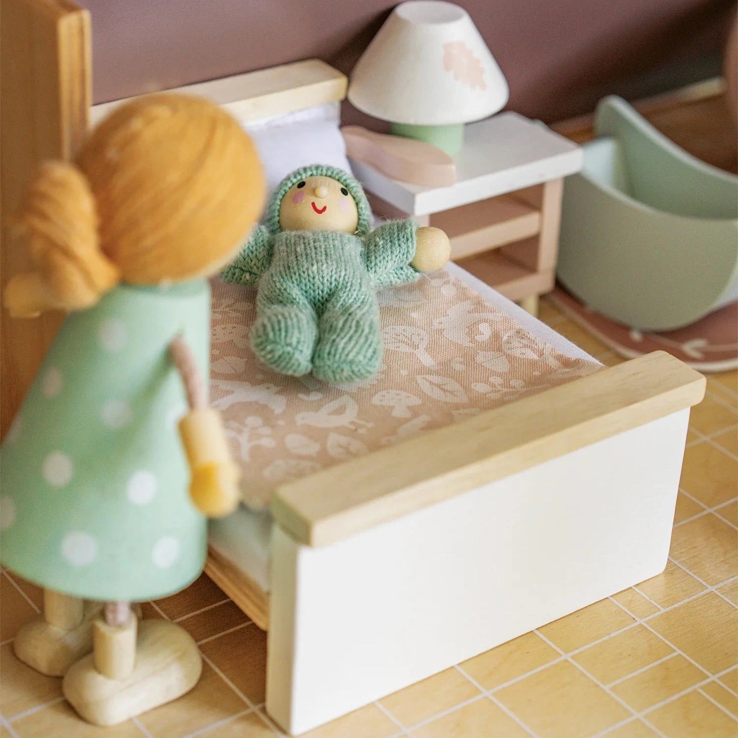 Wooden doll holding a smaller wooden doll on a white background