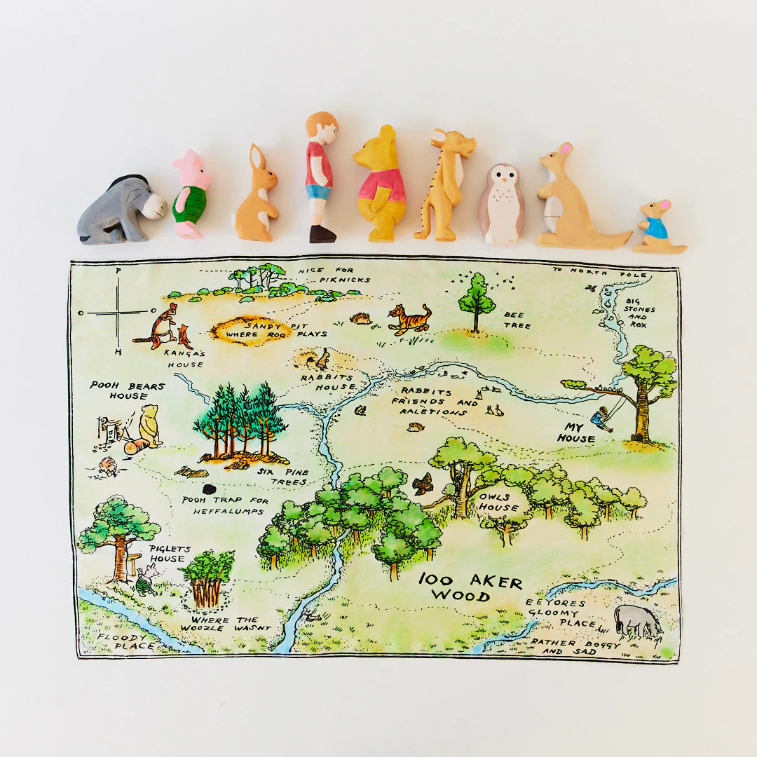 Map of 100 Acre Wood with character figurines on a white background