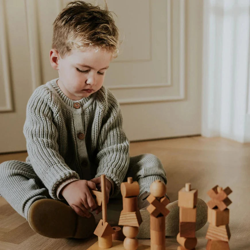 Child playing with wooden toys on a wooden floor