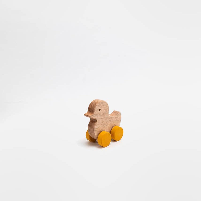 Wooden duck toy with wheels on a white background