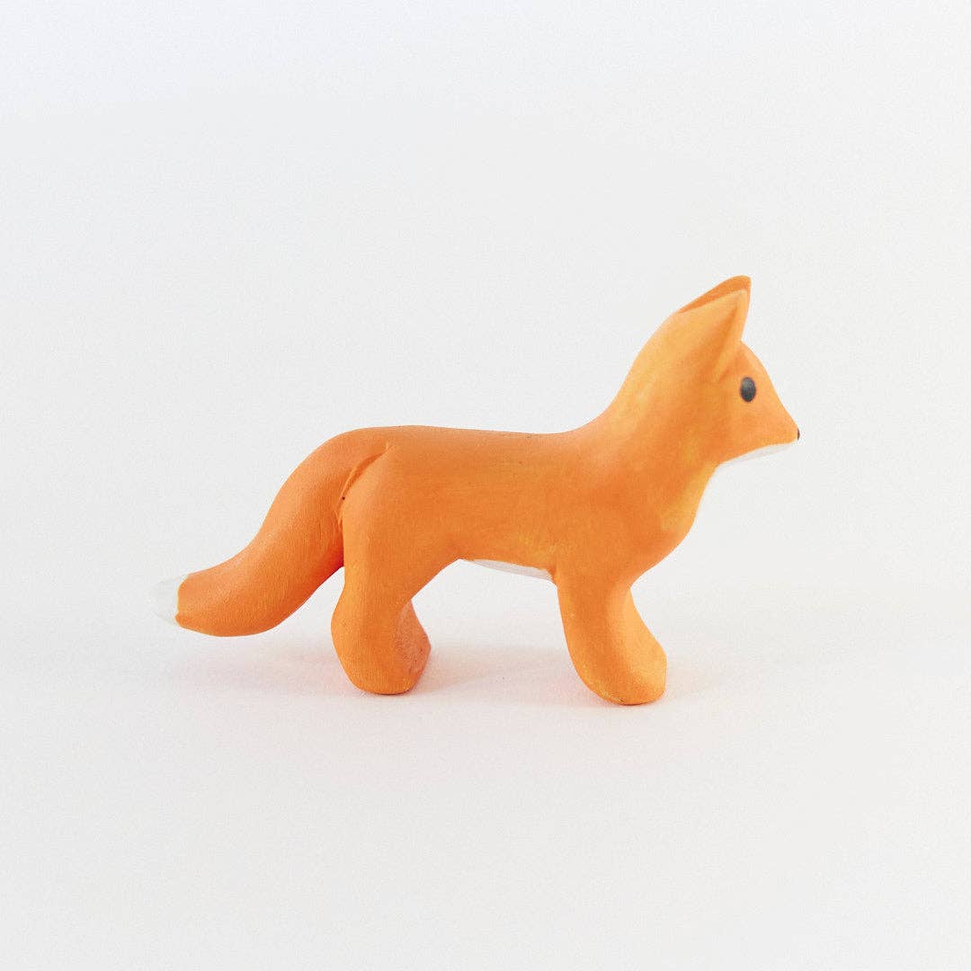 A small orange fox figurine with a black eye, standing on a plain white background.
