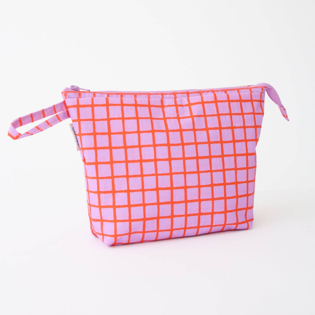 A pink and orange grid-patterned zippered pouch with a matching wrist strap, photographed on a clean white background.