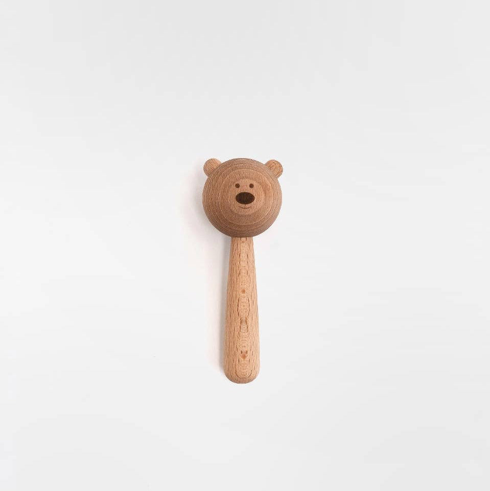 Wooden rattle with a bear handle on a white background