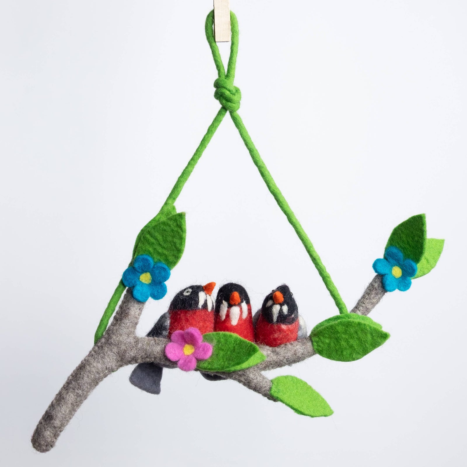 Felt birds on a branch with flowers and leaves against a white background