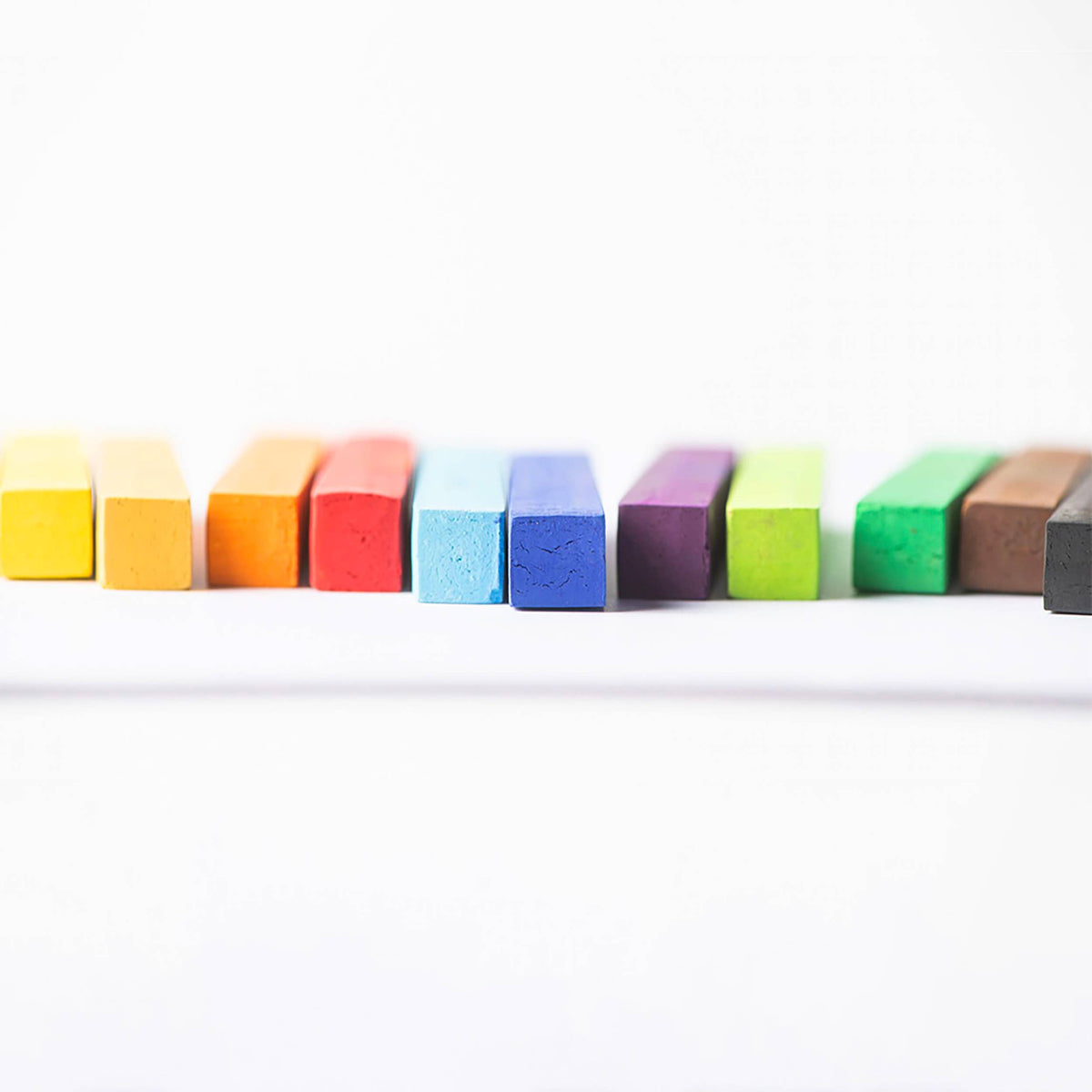 Row of colorful pastels on a white background