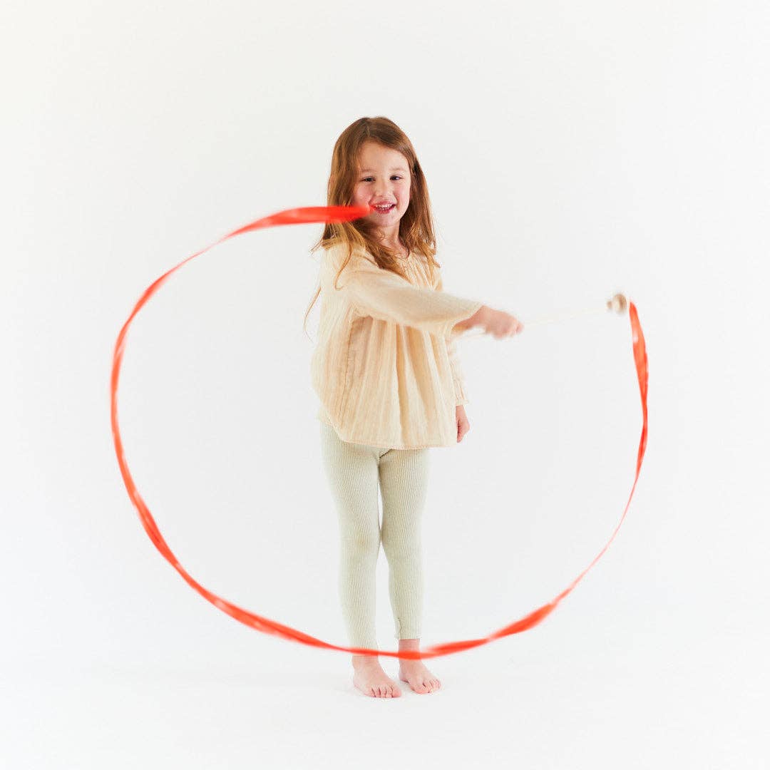 Red silk streamer with wooden mushroom handle on a white background