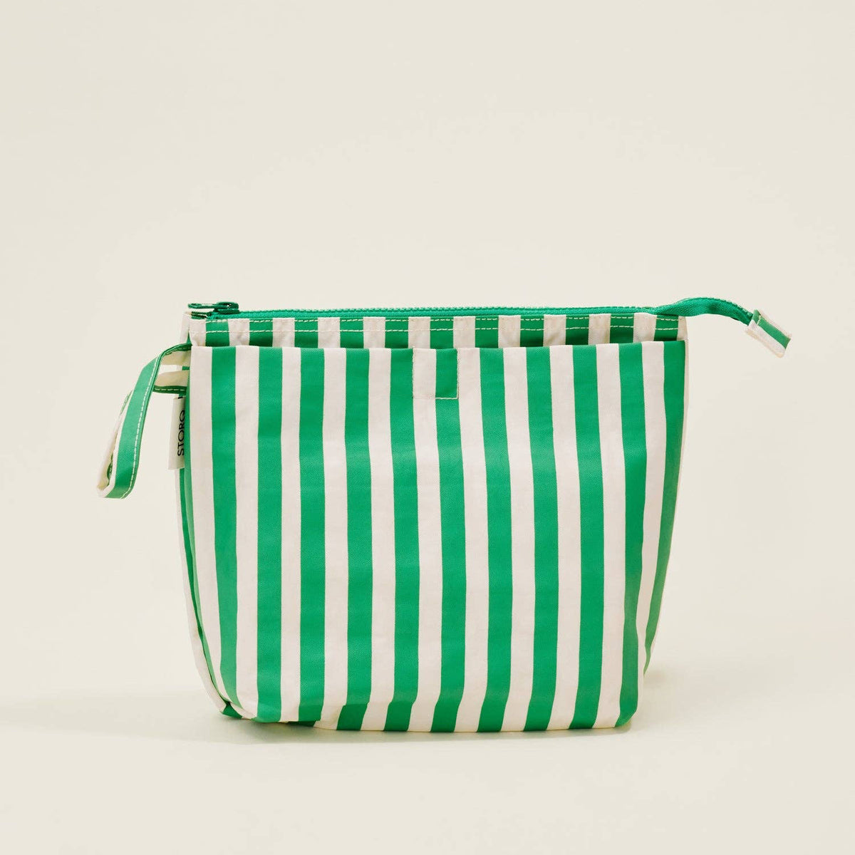 Green and white striped bag on a beige background