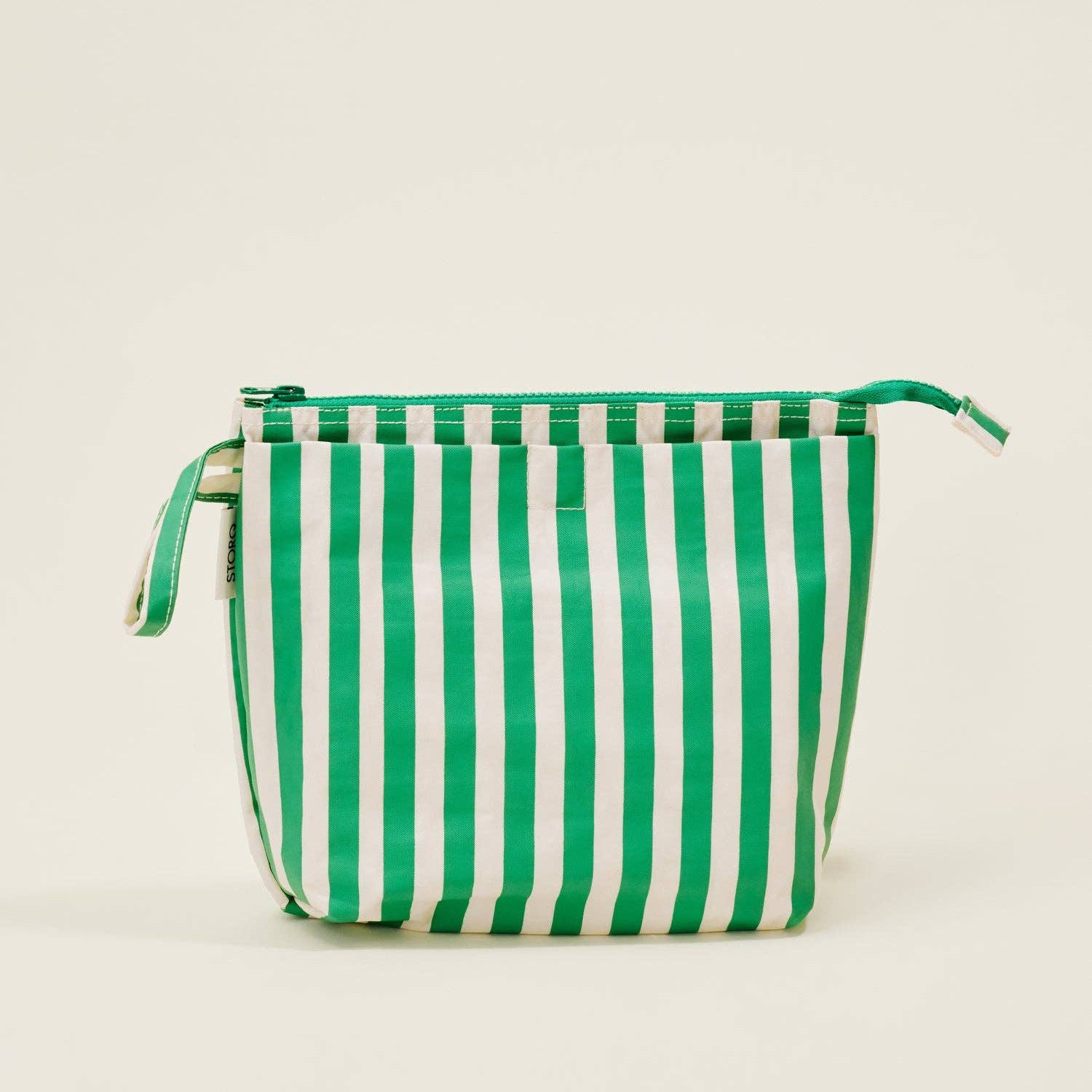 Green and white striped bag on a beige background