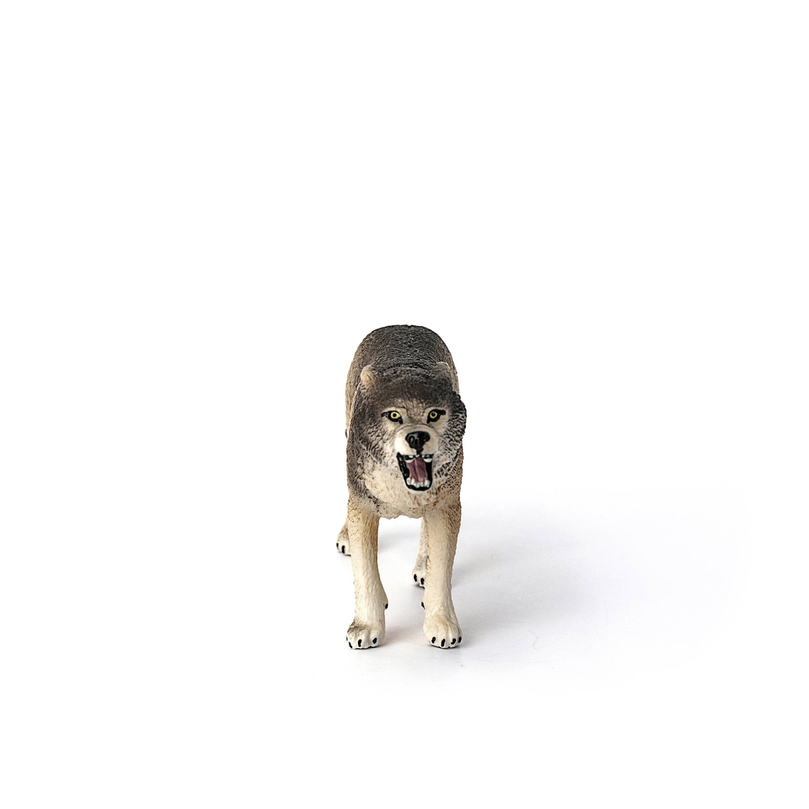 Wolf figurine with an open mouth on a white background