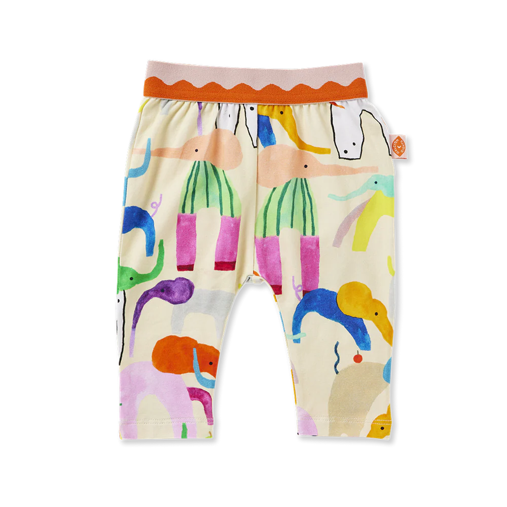 Child wearing a colorful outfit with animal prints on a yellow background