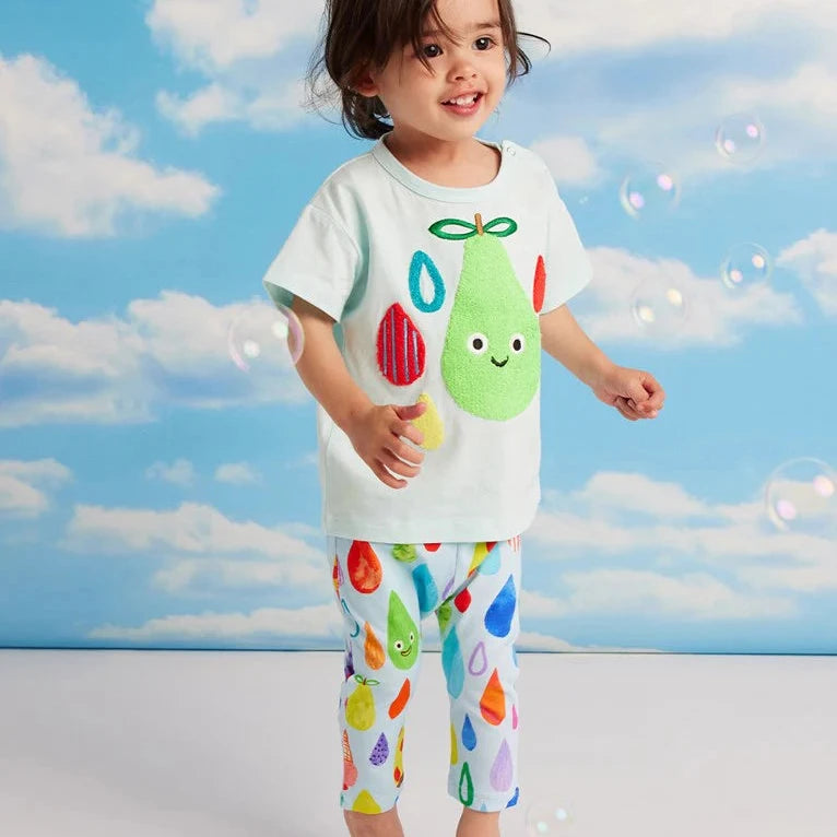 Child wearing a colorful outfit with a rain drop design against a blue sky background