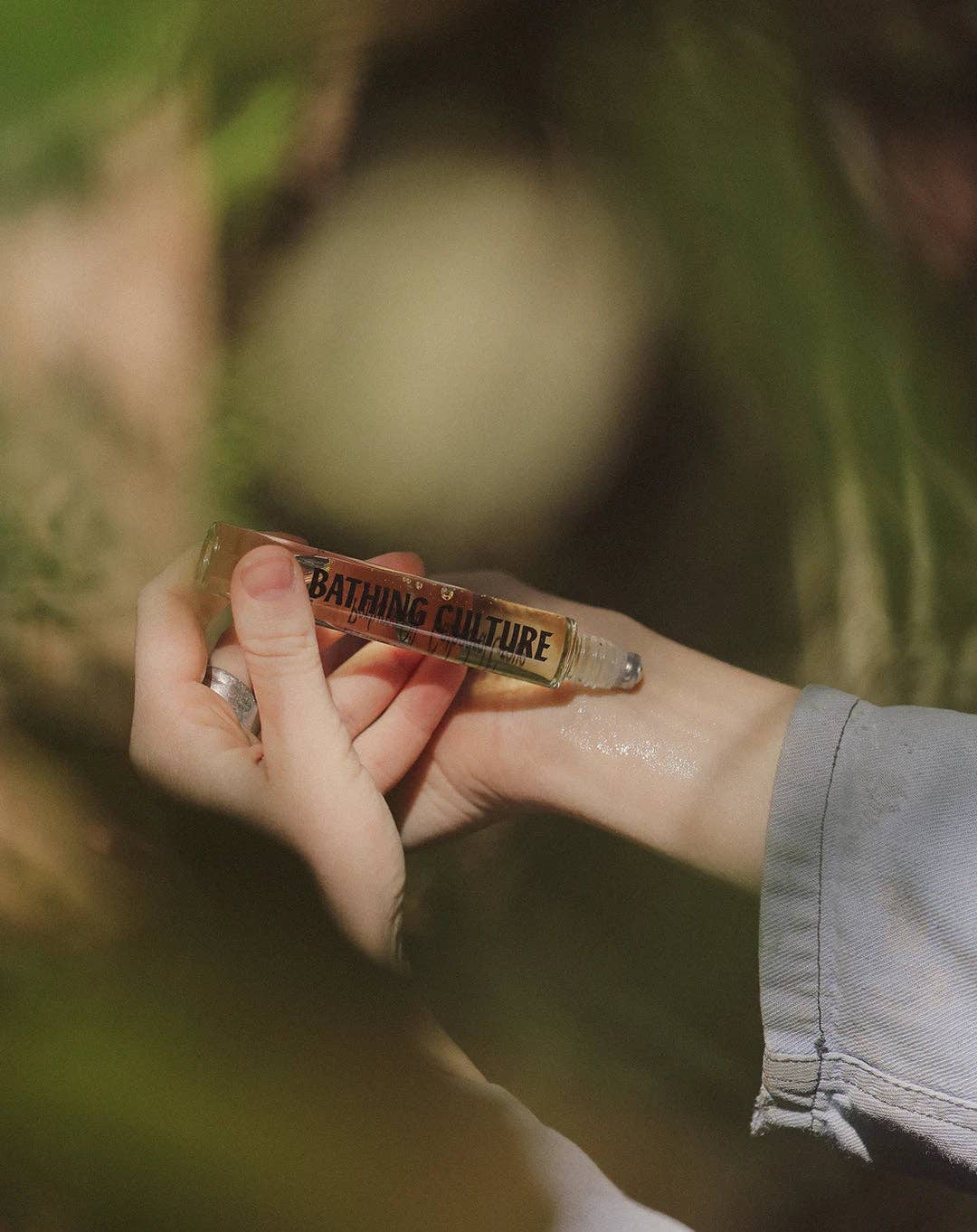 person applying perfume roller