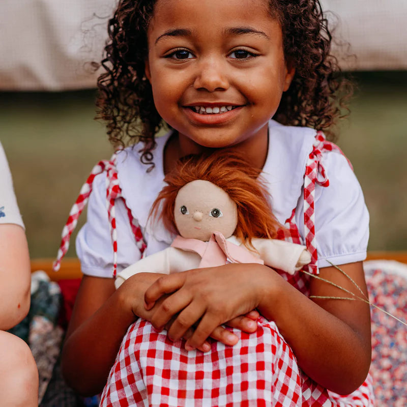 Child holding a doll with a blurred background
