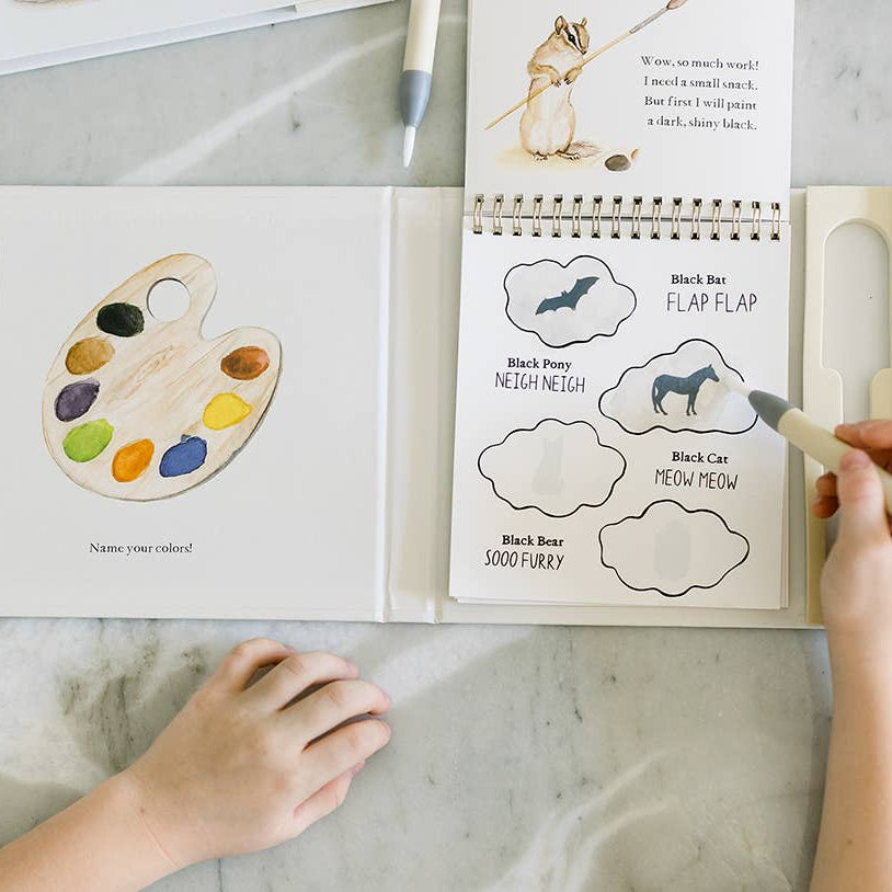 Children's book with a color palette and animal illustrations on a marble surface.