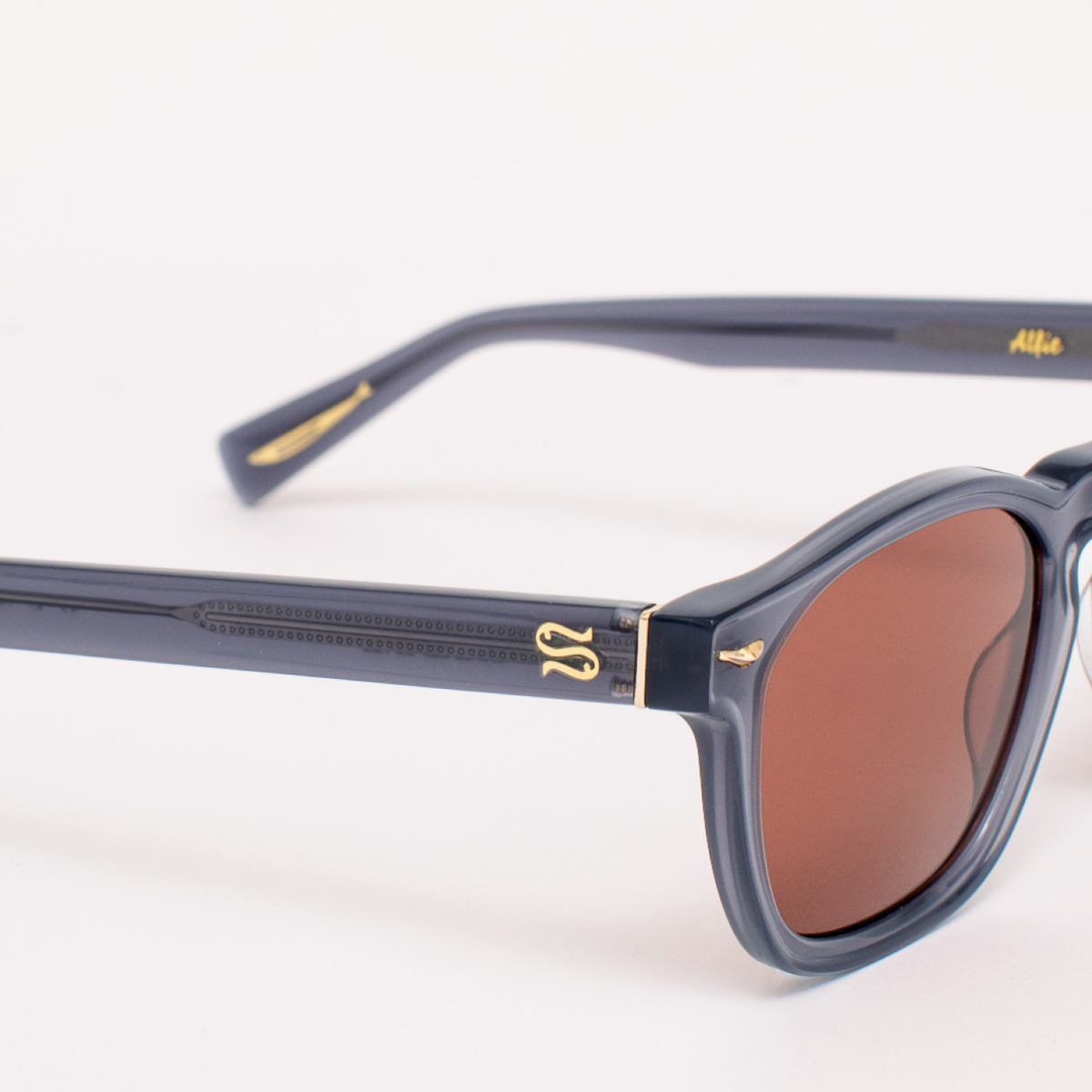 Sunglasses with a dark frame and brown lenses on a white background