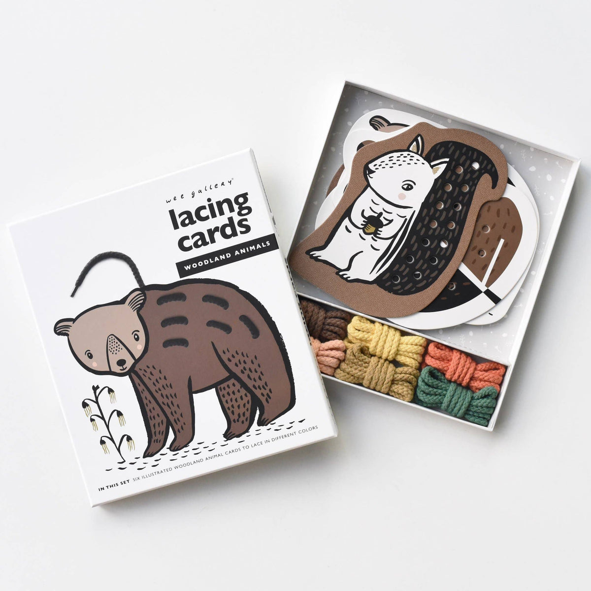 Lacing cards with animal illustrations and yarn on a white background