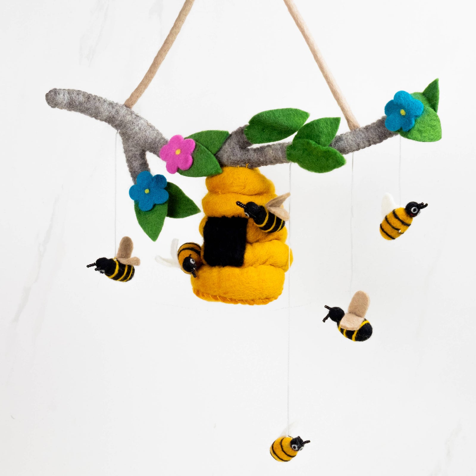 Children's mobile with bee and flower decorations on a white background
