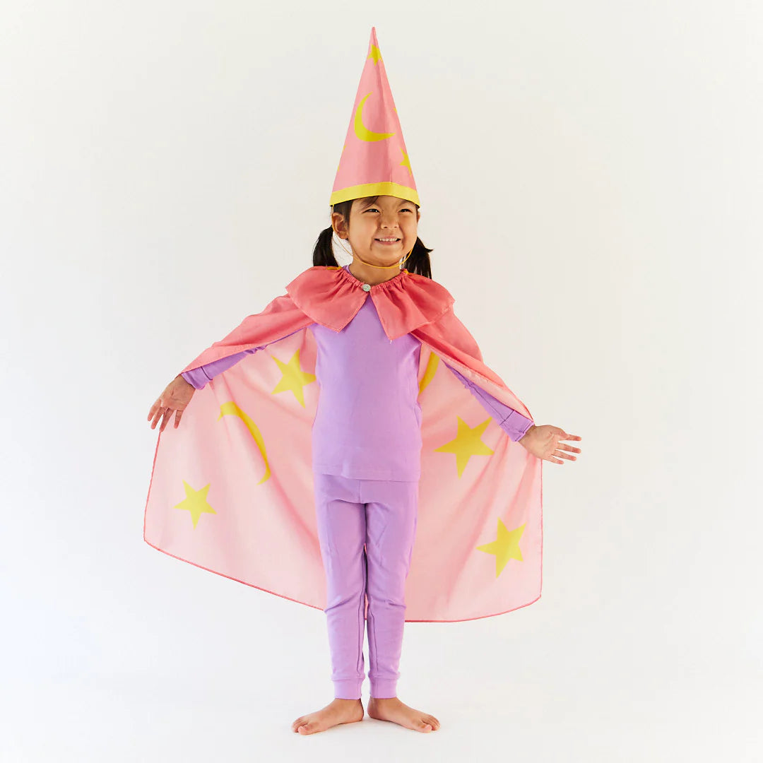 Child wearing a pink superhero costume with a cape and yellow star accents on a white background