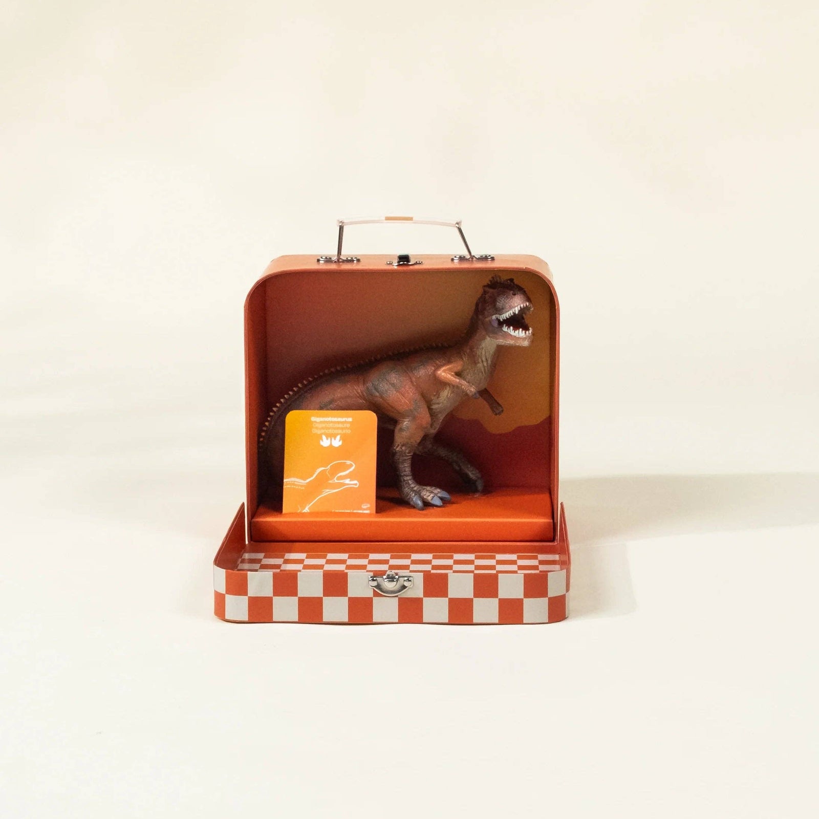 Dinosaur toy in a red suitcase with a checkered bottom on a white background