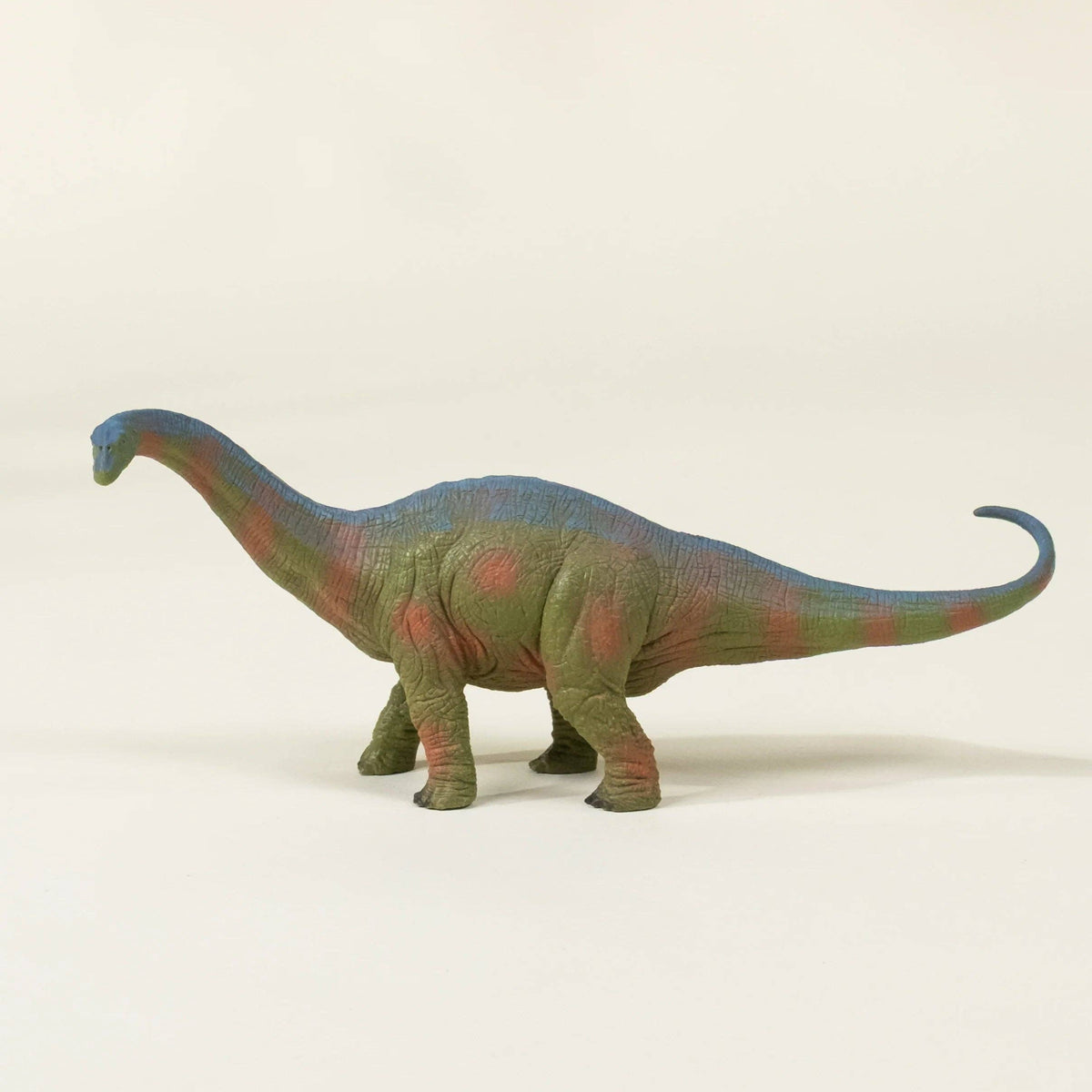 Dinosaur toy figure on a beige background