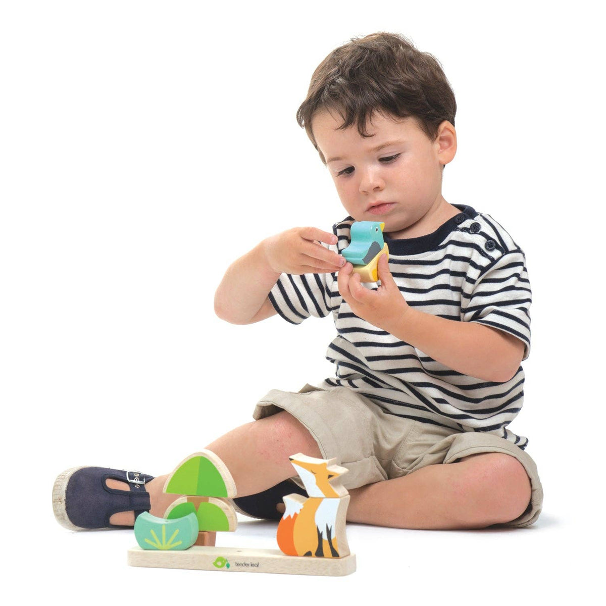 Child playing with wooden animal toys on a white background