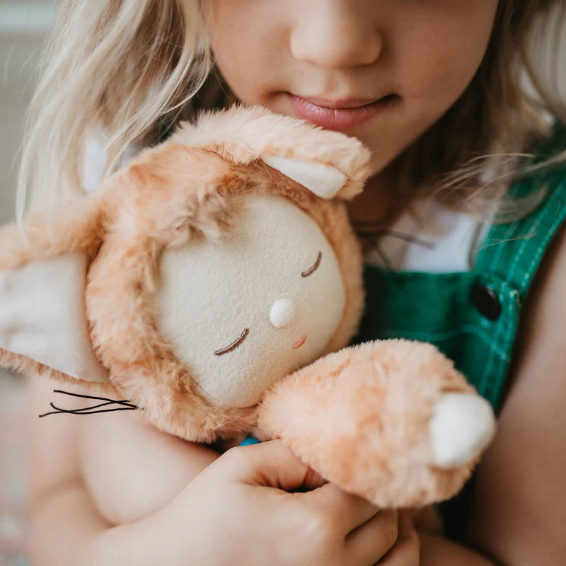 Child holding a plush cat toy with a blurred background
