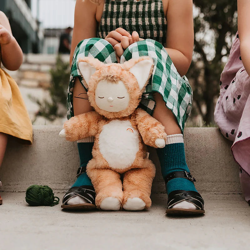Child holding a plush cat toy with a blurred background