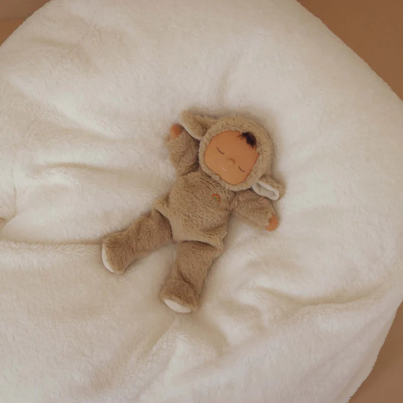 Stuffed toy resembling a baby in a brown outfit on a soft white surface