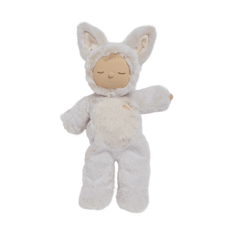 Sleeping fox doll in a white outfit on a wooden stand against a beige background