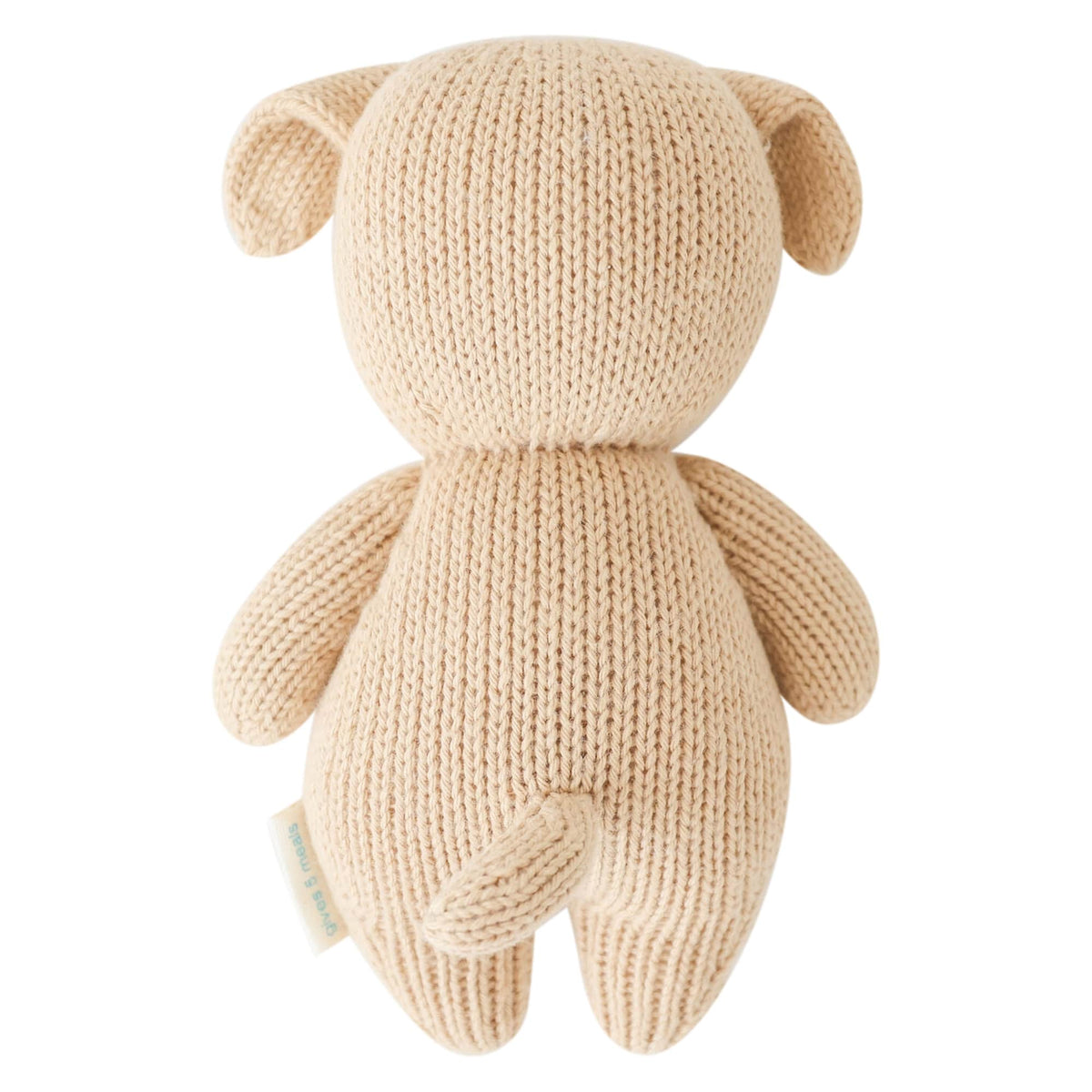 A cream-colored knitted plush toy shaped like a dog shown from the back against a solid white background.