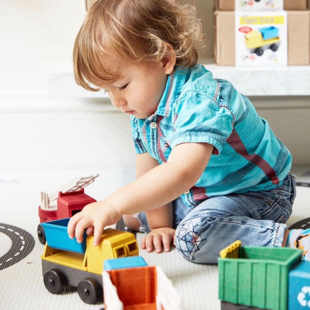 A plastic tipper truck toy with a blue bucket and yellow body on gray chassis with black wheels.