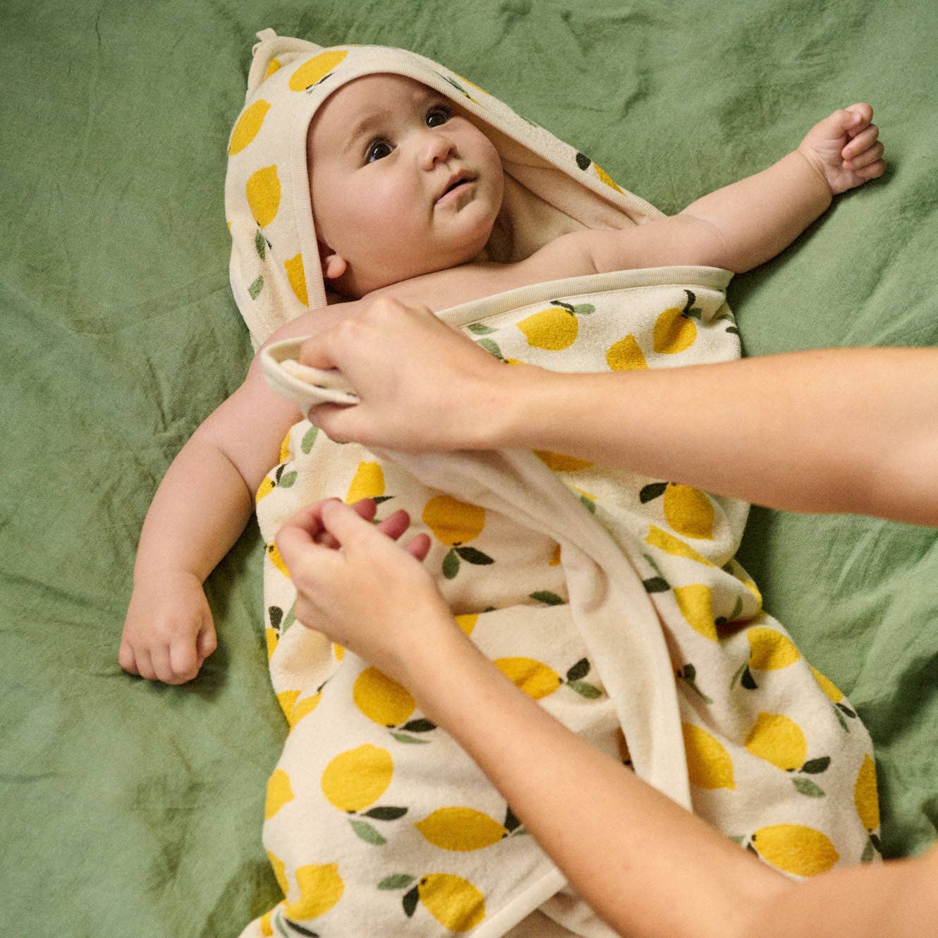 Organic cotton hooded bath towel with lemon pattern on a white background