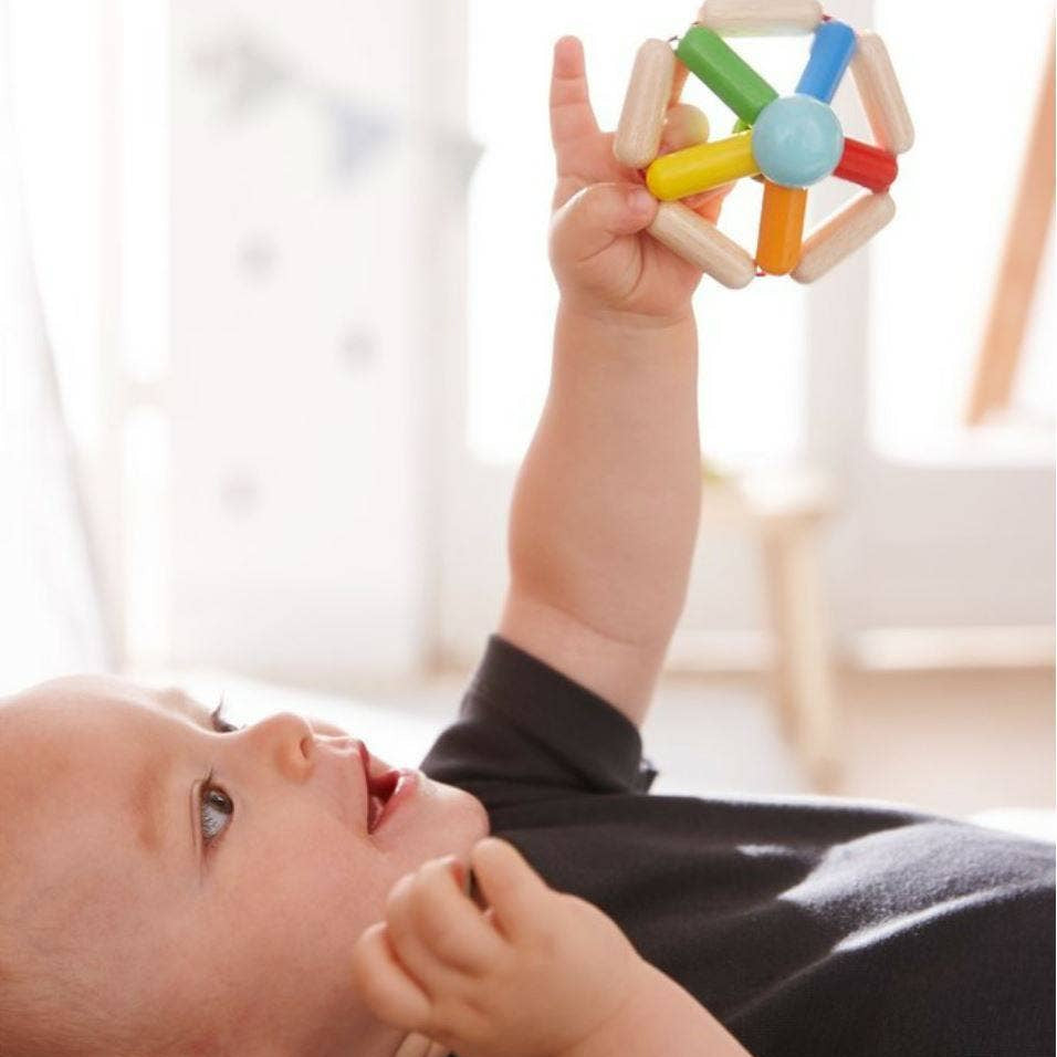 Baby playing with a colorful toy indoors