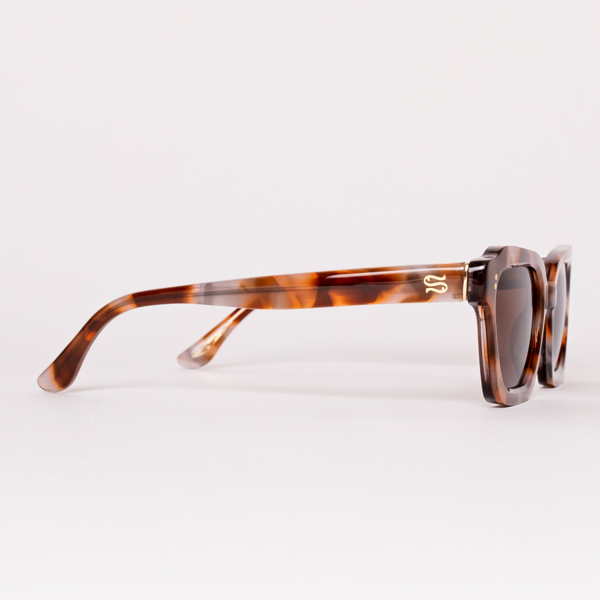 Sunglasses with tortoiseshell frame and dark lenses on a white background