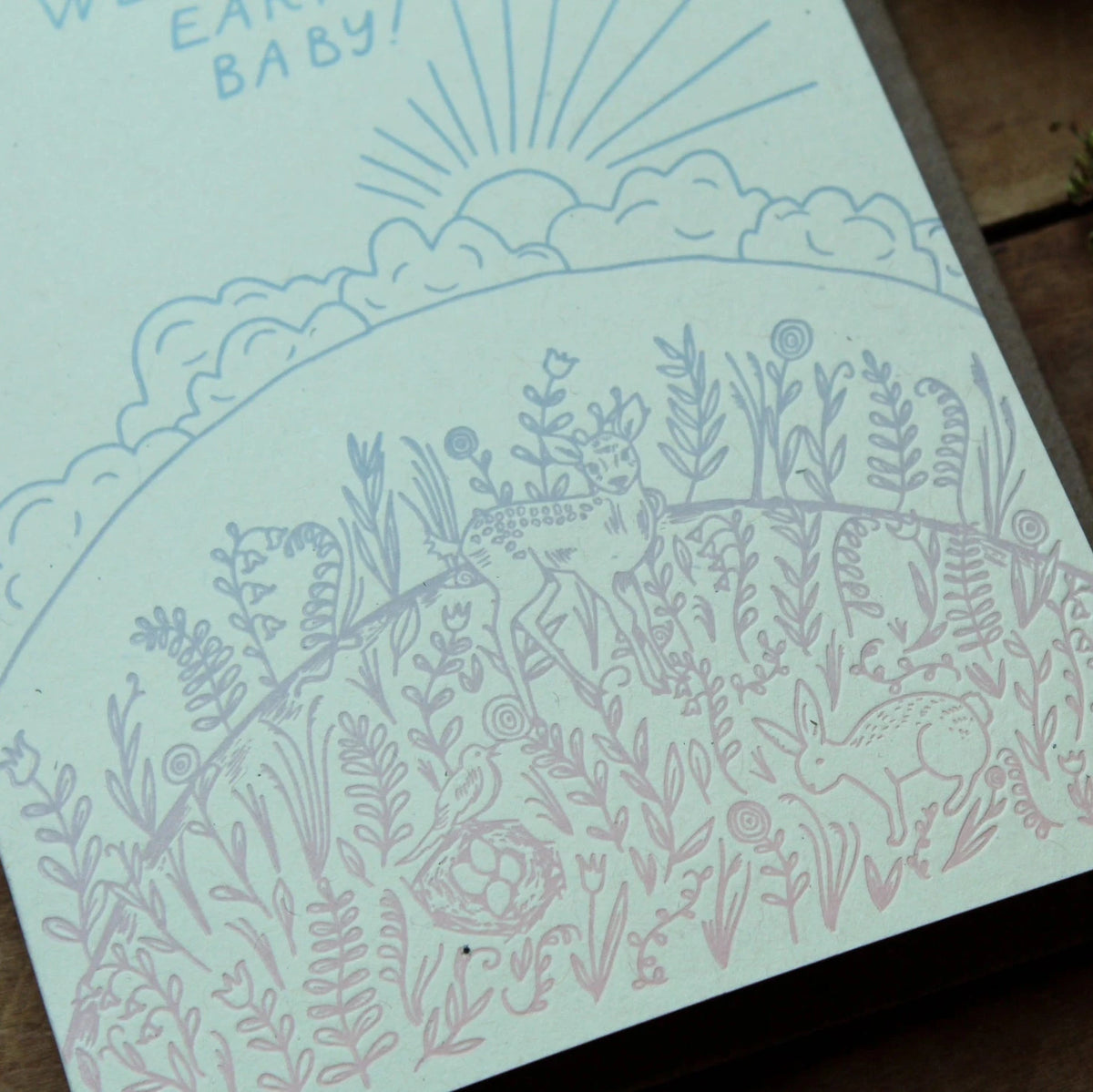 Card with nature-themed design on a wooden surface