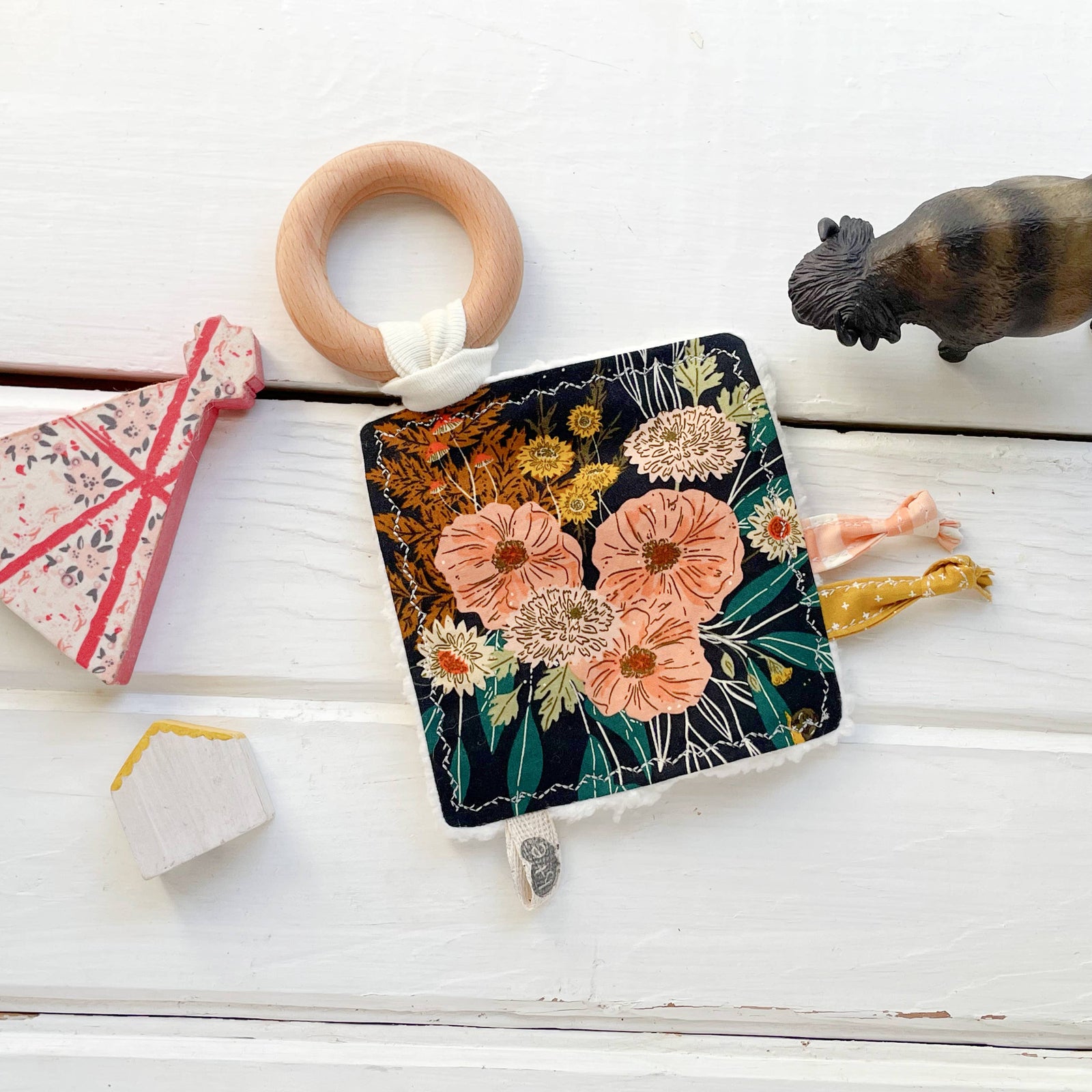 plush crinkle toy with floral pattern and wooden ring