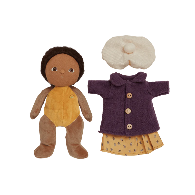 Toy doll wearing a purple coat and white hat , yellow dress on a light blue background with decorative flowers.