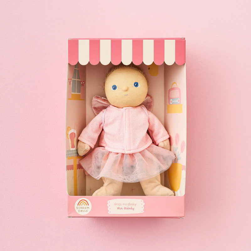 Toy baby doll in a pink outfit with a matching box on a pink background