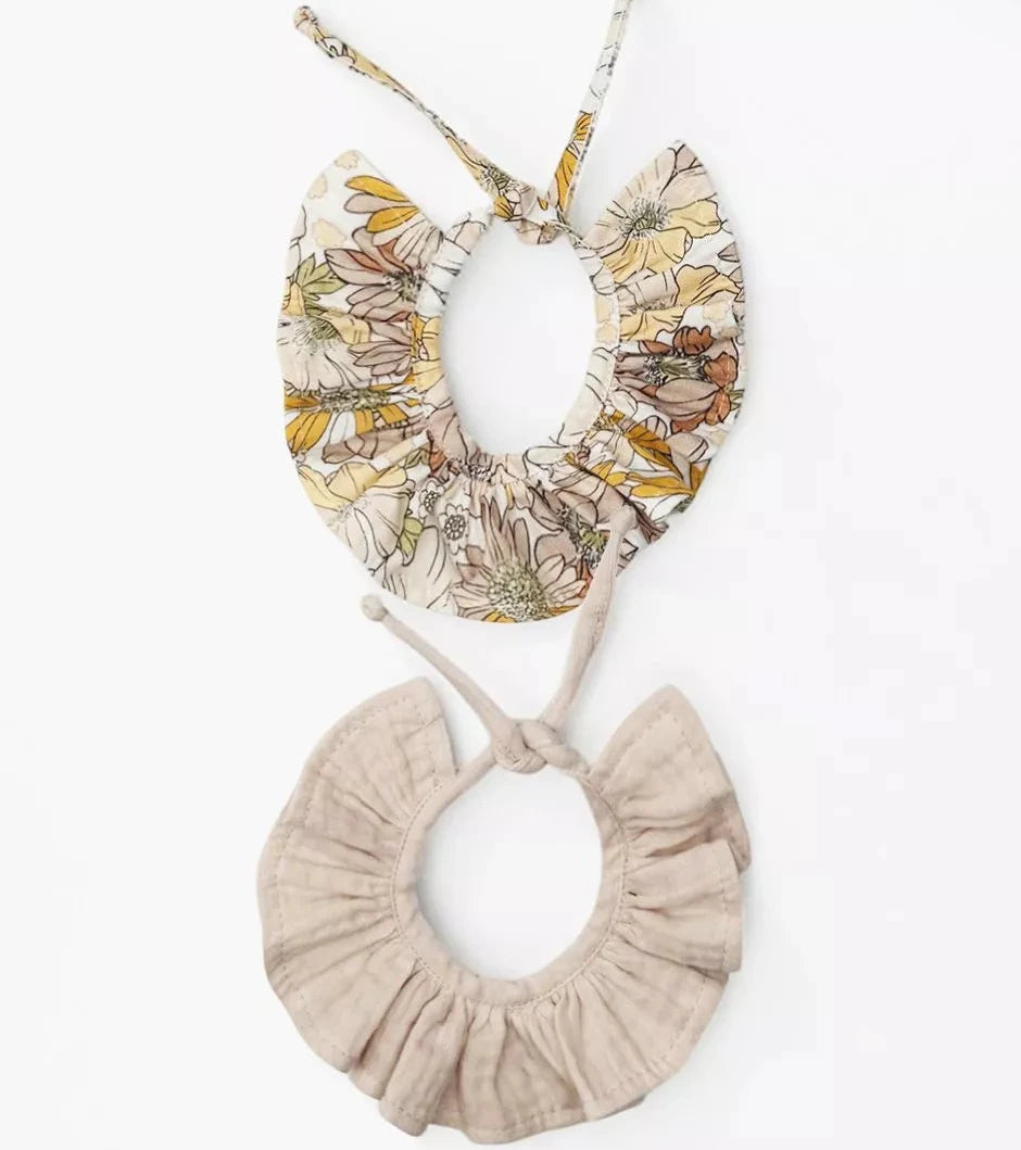 Pair of floral and beige baby doll collars on a white background