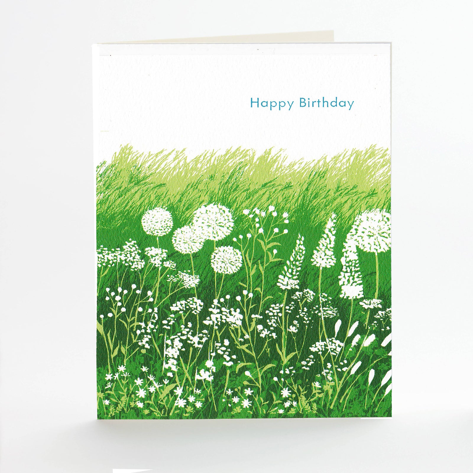 Greeting card with a field of green grass and white flowers, and 'Happy Birthday' text.