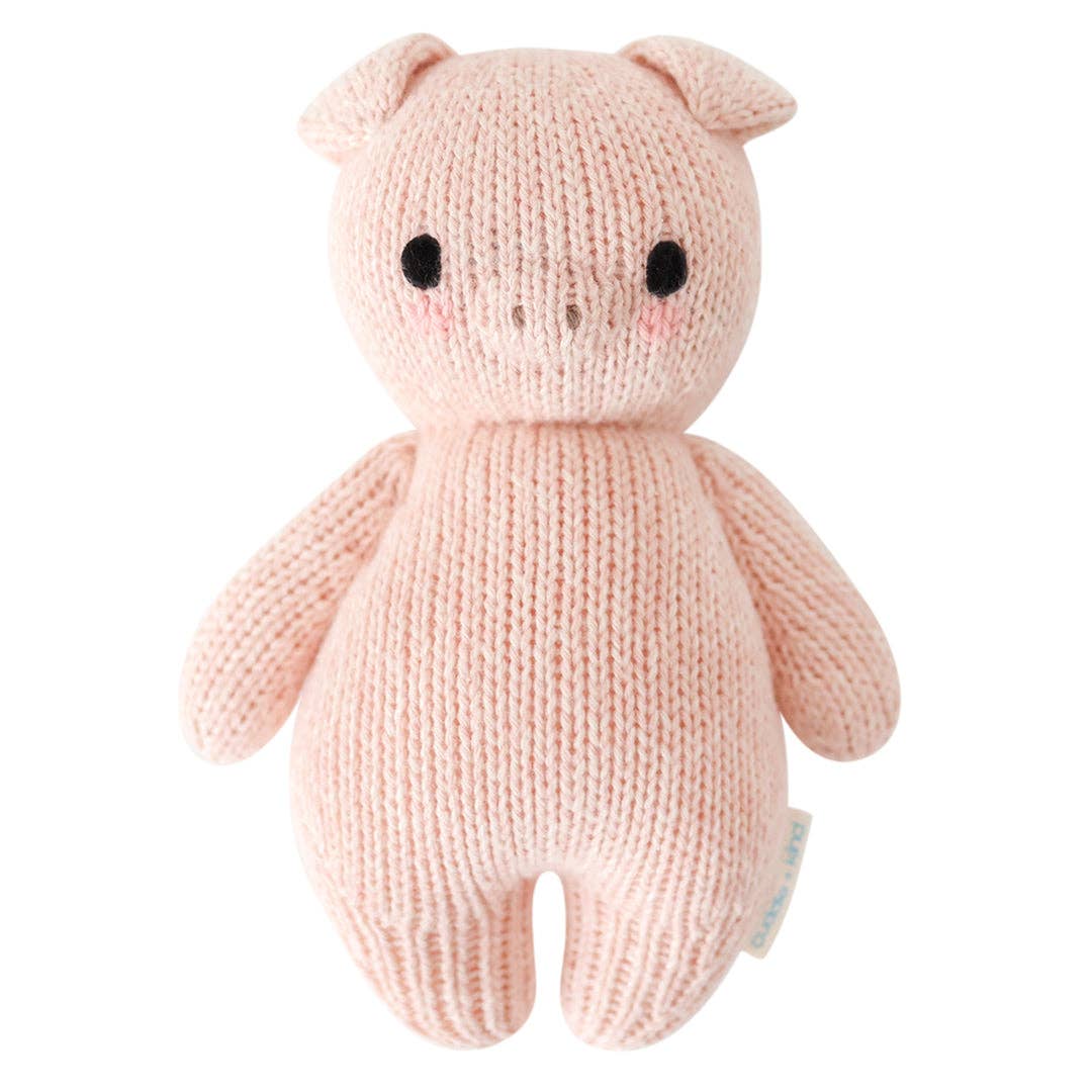 Knitted pink pig toy on a white background