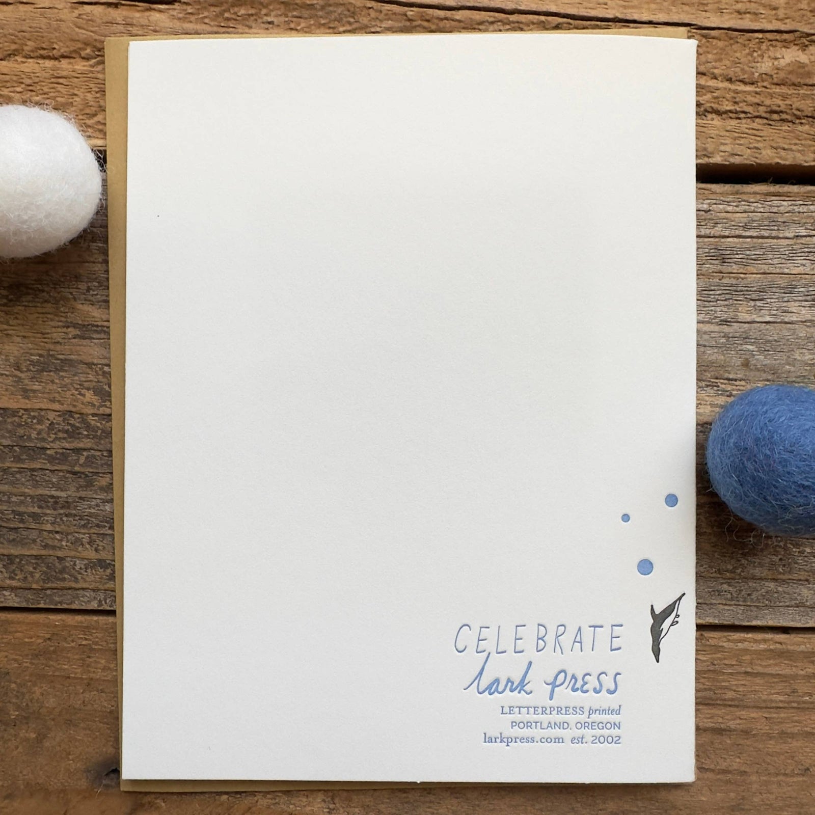 Birthday card with whale illustrations on a wooden surface