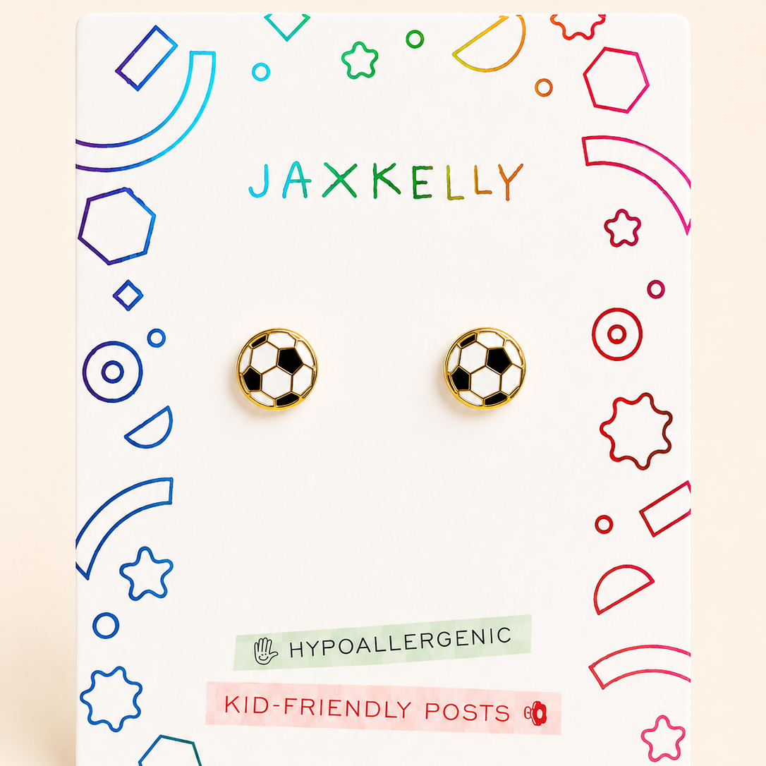A pair of soccer-ball stud earrings displayed on a white JAXKELLY brand backing card. The backing card features colorful soccer balls and text highlighting features like 'Hypoallergenic' and 'Kid-Friendly Posts'.