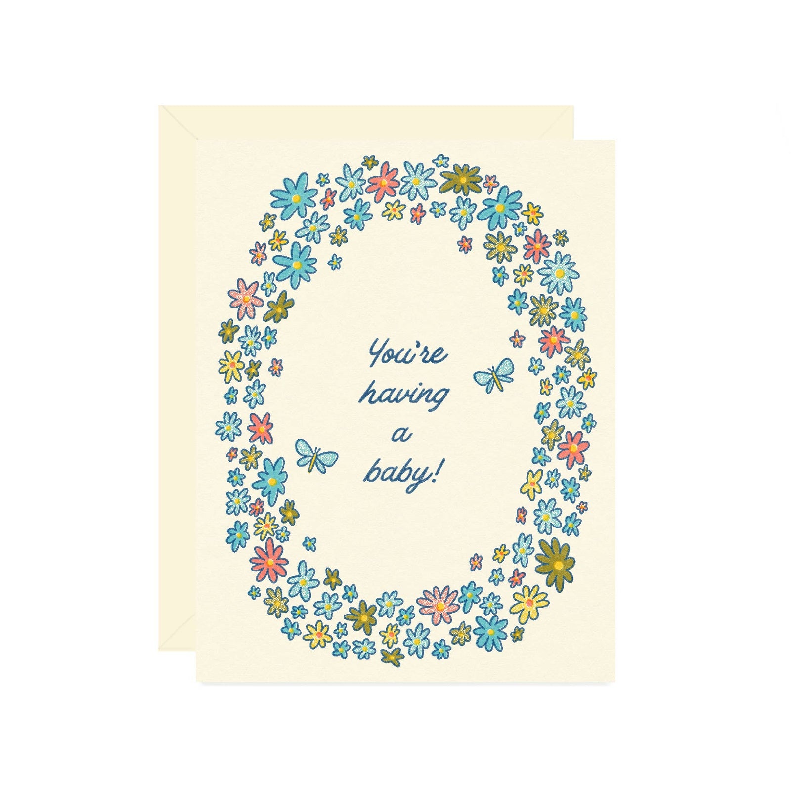 A baby shower greeting card with a cream-colored background, featuring a colorful floral wreath border and the text 'You're having a baby!' in blue script. A matching cream envelope is visible behind the card.