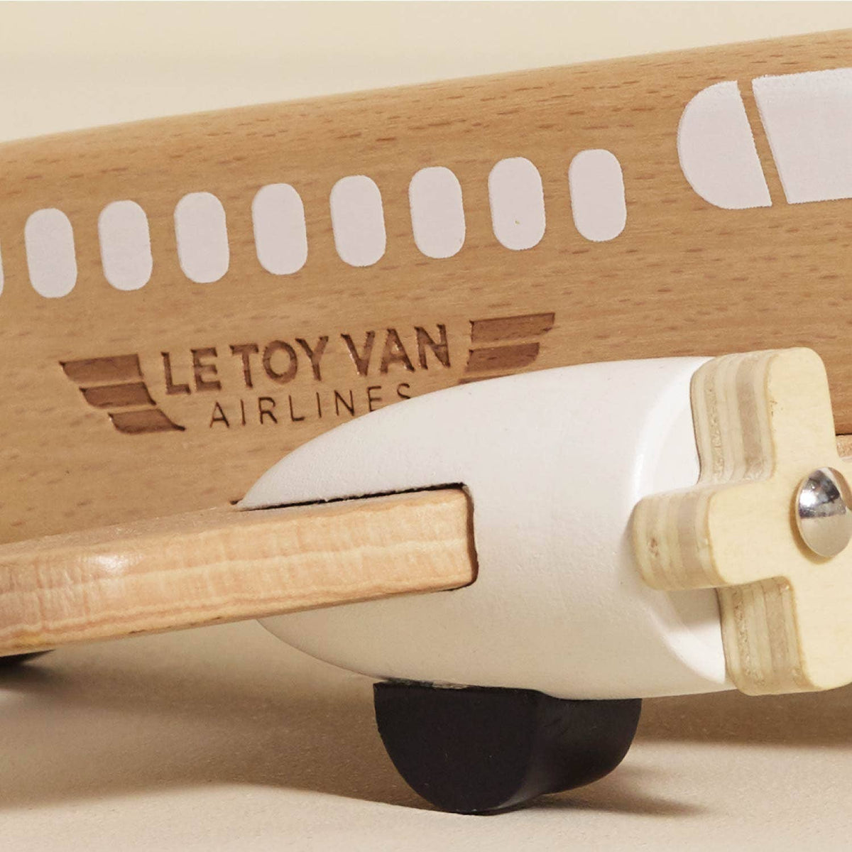 Wooden toy airplane with 'Le Toy Van Airlines' branding on a beige background