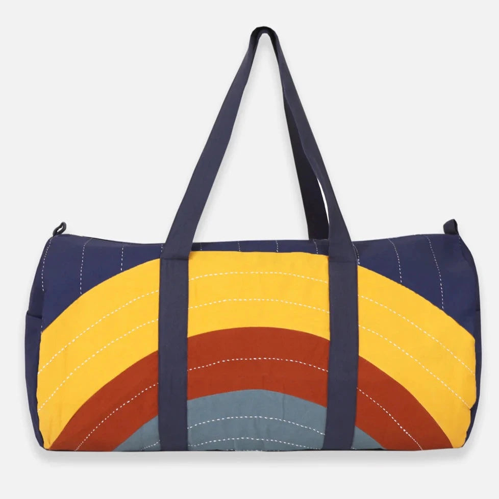 woman carrying large duffle bag with yellowed and grey strips
