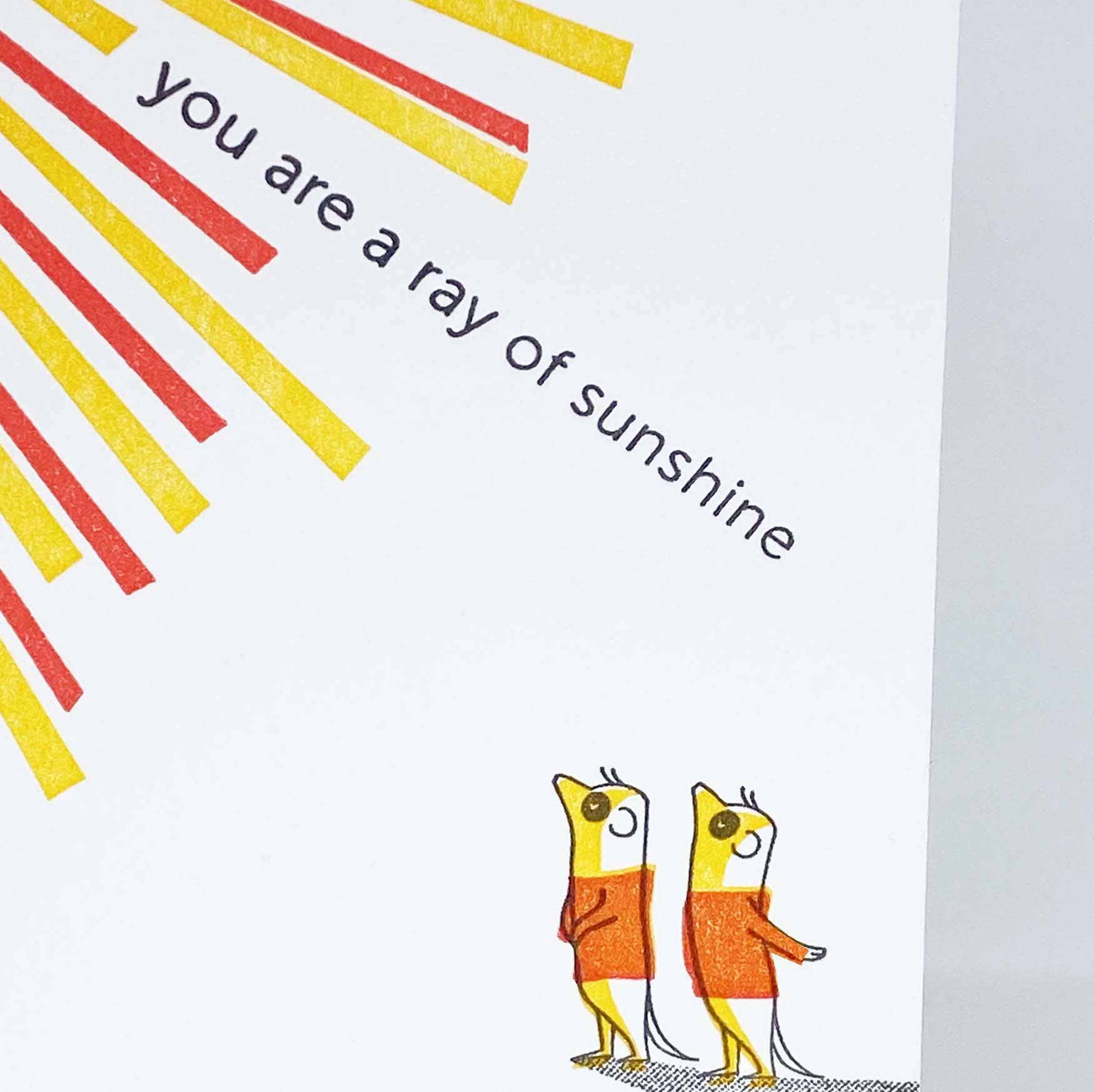 Greeting card with sunburst design and birds on a branch, featuring the text 'you are a ray of sunshine'.